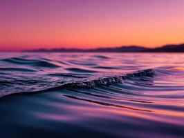 Waves gently lap the shore at sunset by the sea photo