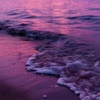 Waves gently lapping against the shore at sunset photo
