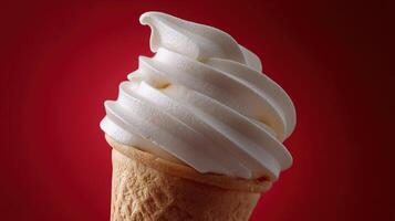 Soft serve ice cream cone with creamy swirls on a red background photo