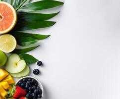 Fresh fruits arranged with green leaves on a white background photo