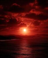 Stunning sunset over the ocean with dramatic red hues photo