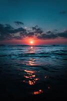 Beautiful sunset over the ocean reflecting on calm waters photo