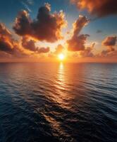 Sunset over calm ocean with vibrant clouds lighting up sky photo