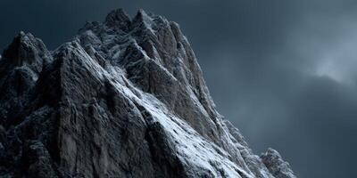 Snow-capped mountain peaks under dramatic cloudy sky photo