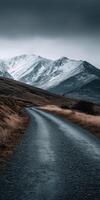 Winding road through snowy mountains in a cloudy landscape photo