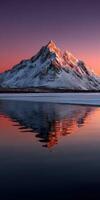 Snow-capped mountain reflecting in tranquil water at sunset photo
