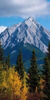 Majestic mountain peak surrounded by vibrant autumn forests photo