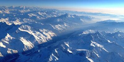 Majestic snowy mountains under a clear blue sky at dawn photo