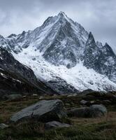 Snow-capped mountain peak under cloudy sky in winter season photo