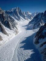 Snowy mountain landscape with glacial river under clear sky photo