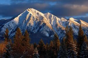 Snow-covered mountain peak under dramatic winter sky photo