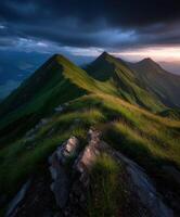 Mountain peaks bathed in sunset glow under dark clouds photo