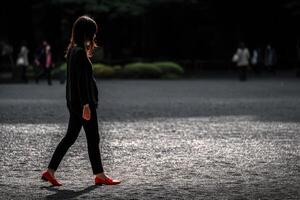 Woman walking in a park during the day with sunlight photo