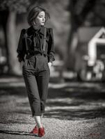 Woman walking in stylish outfit on a sunny day in the park photo