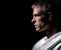 Stoic man in contemplation against a dark background expressing deep thoughts photo