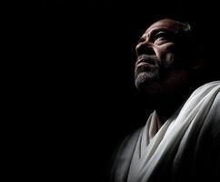 Stoic figure gazing upward in dim light reflecting contemplation and strength photo
