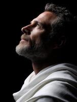 Stoic figure gazing upward in soft light with serene expression photo