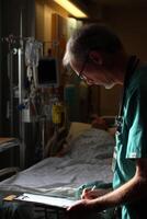 Experienced doctor reviews patient chart in intensive care unit during evening hours photo