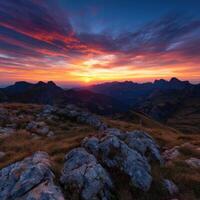 Majestic sunset over mountain peaks reveals vibrant colors in sky photo