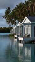 Luxury waterfront villas surrounded by palm trees at dusk in a tropical paradise photo