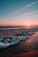 Waves crashing on a sandy beach during a vibrant sunset photo