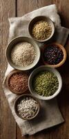 Collection of various organic seeds and grains displayed on wooden surface photo