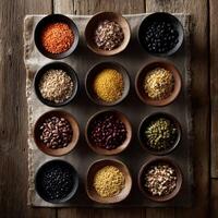 Variety of colorful legumes and grains arranged in wooden bowls on rustic surface photo