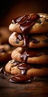 Chocolate chip cookies stacked with melted chocolate drizzling down photo