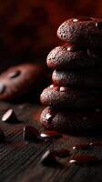 Delicious chocolate cookies stacked on wooden table with chocolate chips scattered photo