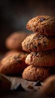 Freshly baked cookies stacked on wooden surface with dark background photo
