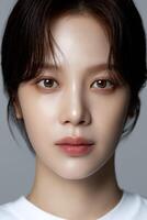 A woman with delicate features and natural makeup gazes directly at the viewer photo