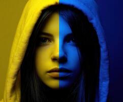 Youthful face half illuminated in yellow and blue tones with a hooded sweatshirt photo
