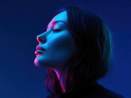 Profile portrait of a woman illuminated by colorful lighting at night photo