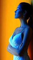 Woman in elegant dress posed against vibrant wall in serene setting photo