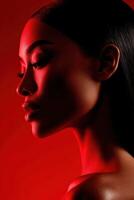 Elegant profile of a woman with dramatic red lighting in a studio setting photo