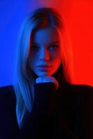 Model posing with dramatic lighting in blue and red hues during indoor shoot photo
