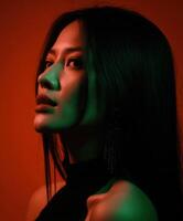 A woman poses gracefully in a studio lit with red and green hues photo
