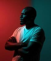 Man in t-shirt poses thoughtfully against colorful backdrop in studio lighting photo