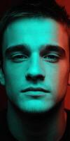 Close-up portrait of a young man with dramatic lighting and intense expression photo
