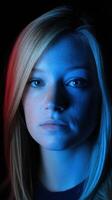 Portrait of a young woman with blue and red lighting on dark backdrop photo