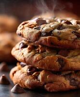 Freshly baked chocolate chip cookies stacked on a dark surface photo