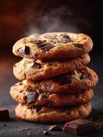 Freshly baked chocolate chip cookies stacked on a dark background with steam rising photo
