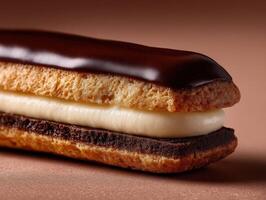 Delicate chocolate eclair with creamy filling in a warm light setting photo