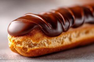 Delicious chocolate eclair resting on a smooth surface in a warm setting photo