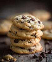 Chocolate chip cookies stacked high on a rustic wooden table photo