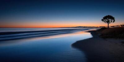 Sunset over the calm ocean waves at a serene beach location photo