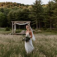 Bride walks gracefully through a field during golden hour photo