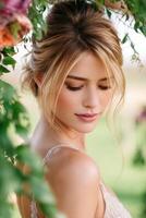 Elegant bride with soft smile surrounded by lush greenery photo