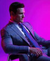 Stylish businessman poses confidently in vibrant lighting photo