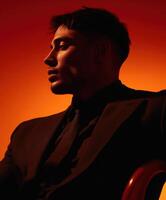 Portrait of a man in a tailored suit against an orange backdrop photo
